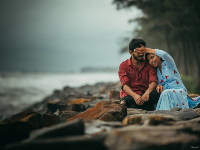 Young couple sitting in the beach side & enjoying their pre-wedding photoshoot